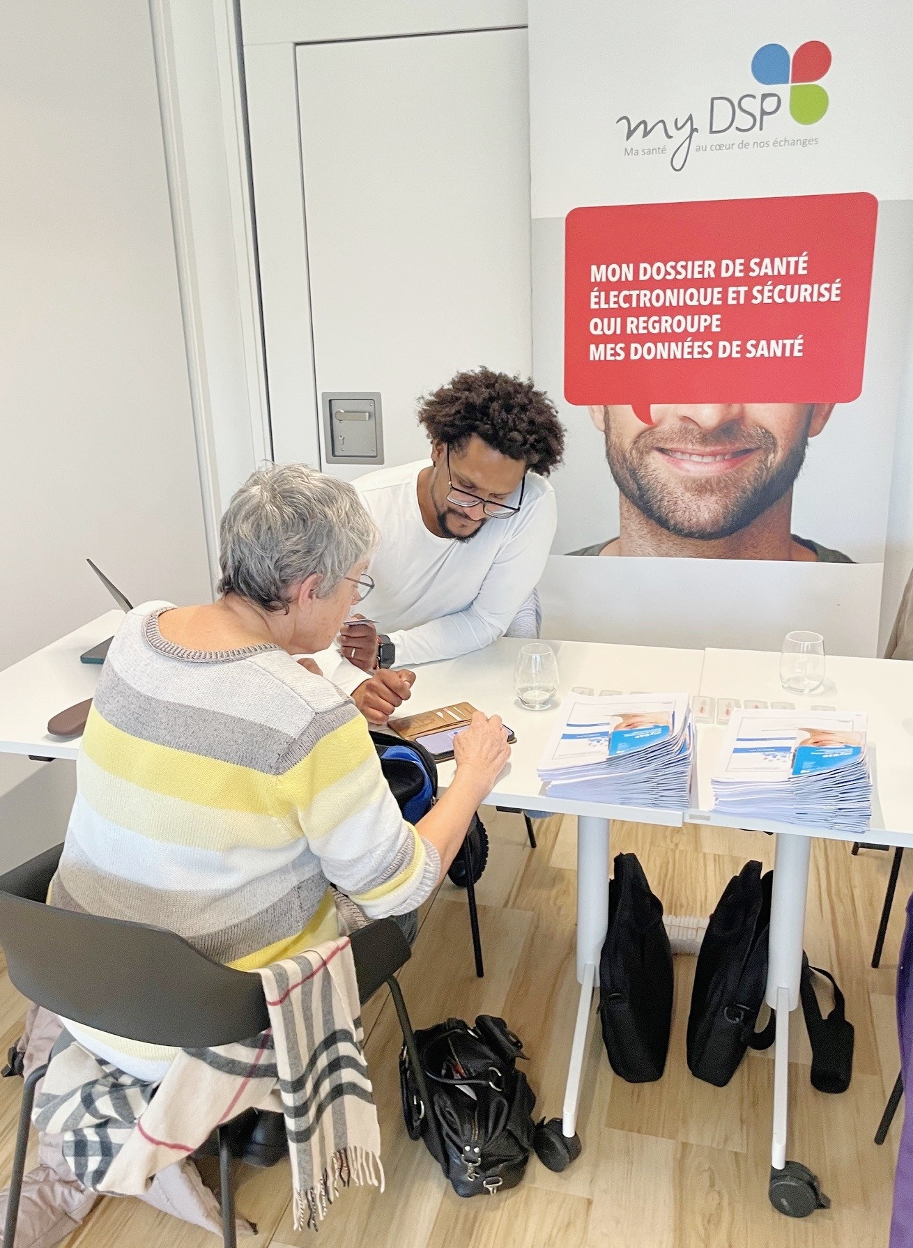 Membre de l'Agence aidant une personne âgée sur son smartphone